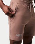 Detailed view of the secure invisible pocket with locking zipper on men’s brown performance shorts.