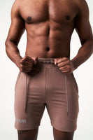 Detailed view of men’s brown performance shorts showcasing the tonal drawstring and wide elastic waistband.