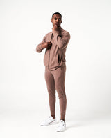 Men’s performance zip-up jacket in brown side profile showcasing moisture-wicking material and streamlined design for agility.