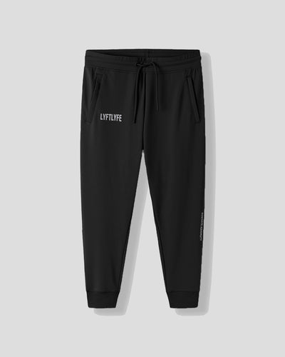 Black jogger pants with a brand logo on a light gray background