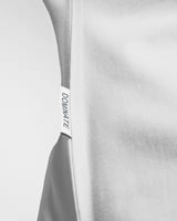 Detailed view of the LYFTLYFE side flag tag on the off-white Contour Tee, adding a signature touch to the fitted men’s t-shirt.