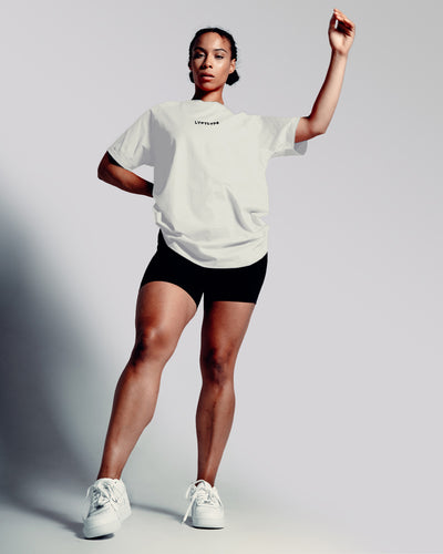 Oversized Contour Women’s Tee in off-white, featuring a moisture-wicking cotton blend and soft crew neckline for all-day comfort.