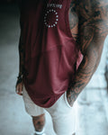 Close up view of Men’s Dominance Cut Sleeve in red wine color, highlighting a scoop hem and performance stretch fabric.