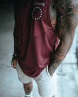 Close up view of Men’s Dominance Cut Sleeve in red wine color, highlighting a scoop hem and performance stretch fabric.