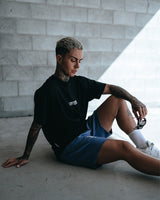 Women’s oversized Contour Tee in black, displayed from the side, highlighting the relaxed cut and breathable performance fabric.