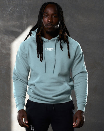 Fitted men's hoodie with LYFTLYFE branding in slate color, styled with black shorts