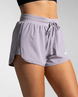 Right side profile of purple women's HIIT shorts highlighting curved leg cut and side panel.