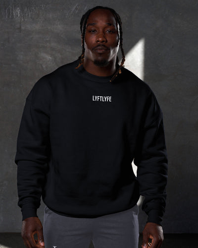 Men’s oversized black crewneck sweater with ultra-plush fleece fabric, 3D rubberized Lyftlyfe logo on the chest, and ribbed cuffs and hem.