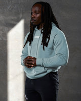 Left side view of slate LYFTLYFE hoodie showing sleeve fit and minimal branding.
