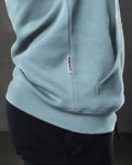 Elite hoodie close-up in slate color highlighting side label and structured kangaroo pocket.