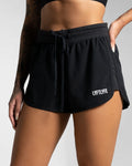 Right side profile of black women's HIIT shorts highlighting curved leg cut and side panel.