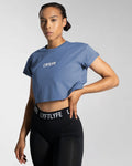 Left side view of the blue Drill Women’s Crop T-shirt, showcasing its fitted cut, soft-stretch fabric, and moisture-wicking properties.