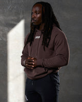 Left side profile of brown LYFTLYFE hoodie showing sleeve fit and minimal branding.