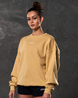 Left side view of women’s yellow oversized crewneck with ultra-soft fleece fabric, ribbed hem, and relaxed fit.