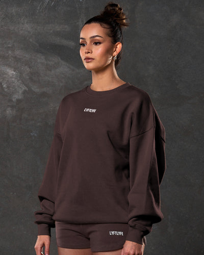 Women’s dark brown Adapt Crew featuring a relaxed oversized fit, centered Lyftlyfe chest logo, and soft fleece fabric.