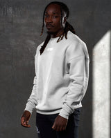 Left side view of men’s oversized crewneck in sand (off-white) with ultra-soft fleece, ribbed cuffs, and a relaxed, comfortable fit.