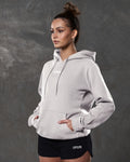 Left side view of white sand hoodie showing kangaroo pocket and tonal drawstrings.