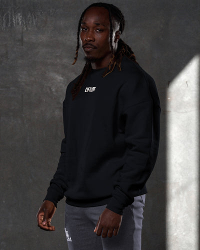 Men’s oversized black crewneck sweater with ultra-plush fleece fabric, 3D rubberized Lyftlyfe logo on the chest, and ribbed cuffs and hem.