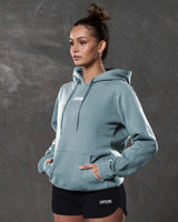 Left side view of slate hoodie showing kangaroo pocket and tonal drawstrings.