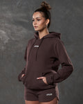 Left side view of brown hoodie showing kangaroo pocket and tonal drawstrings.