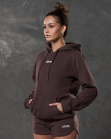 Left side view of brown hoodie showing kangaroo pocket and tonal drawstrings.