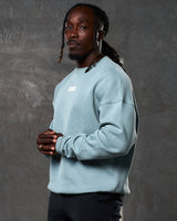 Left side view of men’s light blue oversized crewneck with ultra-soft fleece, ribbed cuffs, and a relaxed, comfortable fit.