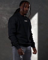 Side profile of men’s black oversized crewneck with ultra-soft fleece, ribbed cuffs, and a relaxed, comfortable fit.
