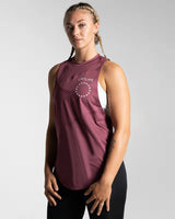 Women’s sleeveless gym tank top in prune shown from the left side, highlighting its lightweight mesh panels and moisture-wicking properties.