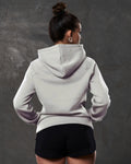 Rear shot of fleece hoodie in white sand , showing contoured fit and ribbed hem.