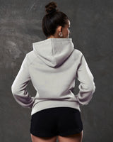 Rear shot of fleece hoodie in white sand , showing contoured fit and ribbed hem.