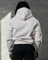 Rear angle of LYFTLYFE Elite hoodie in white sand showing fitted hem and relaxed hood.