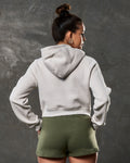 Back view of women’s cropped fleece hoodie in sand color with double seam detail.
