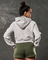 Back view of women’s cropped fleece hoodie in sand color with double seam detail.