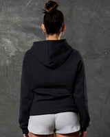 Rear shot of black fleece hoodie showing contoured fit and ribbed hem.