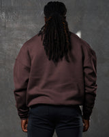 Back view of men’s oversized dark brown crewneck sweater with ultra-plush fleece fabric and ribbed hem for a clean finish.