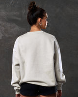 Back view of women’s oversized Adapt Crew in sand (off-white) with lightweight fleece fabric. 