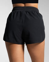 Rear view of black women's HIIT shorts with high-rise waistband and no lining.