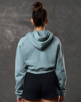 Back view of women’s cropped fleece hoodie in slate color with double seam detail.