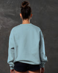 Women’s light blue Adapt Crew, back view showcasing breathable fleece fabric and clean ribbed detailing.