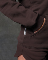 LYFTLYFE hoodie in brown showing sleeve cuff and branded tag near hand pocket.