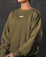 Detailed shot of women’s Adapt Crew in green showcasing Lyftlyfe branding, ultra-soft fleece fabric, and ribbed detailing.