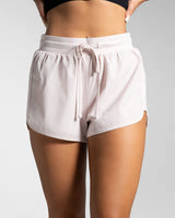 High-waisted light pink women's HIIT shorts with front drawstrings and LYFTLYFE logo.
