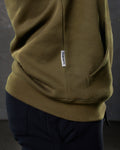 Zoomed view of green LYFTLYFE hoodie pocket and sewn-in Dominate label.
