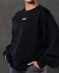 Close-up of the 3D Lyftlyfe logo on the chest of women’s black oversized Adapt Crew.