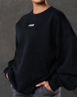 Close-up of the 3D Lyftlyfe logo on the chest of women’s black oversized Adapt Crew.