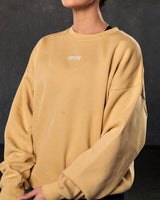 Close-up of the 3D Lyftlyfe logo on the chest of women’s yellow oversized Adapt Crew.