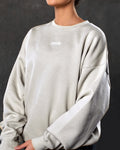 Detailed shot of women’s Adapt Crew in sand (off-white) showcasing Lyftlyfe branding, ultra-soft fleece fabric, and ribbed detailing.