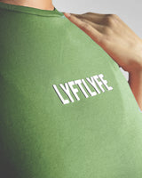 Detailed shot of the white Lyftlyfe logo on the Women’s Drill Crop Tee in green, adding a high-end finish to the fitted design.