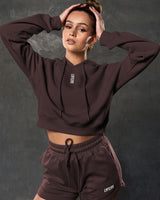 Close-up of LYFTLYFE 3D rubberized logo on chest of brown cropped hoodie.