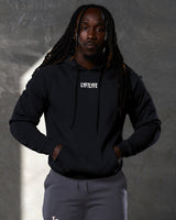 Relaxed pose featuring Elite hoodie in black with bold chest branding.